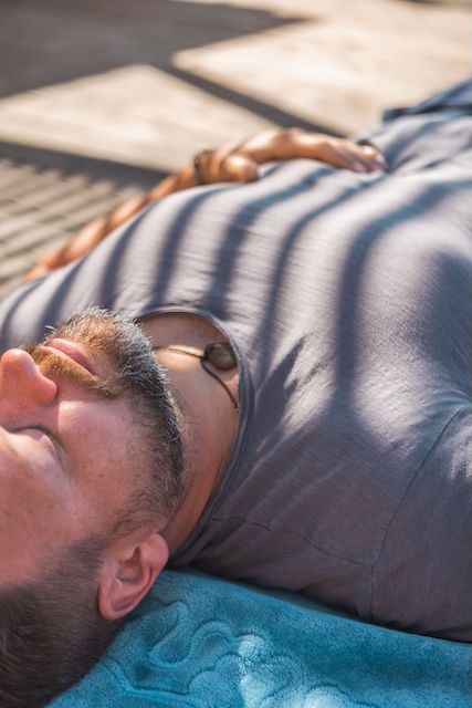 Ein Mann liegt entspannt in der Sonne, die Augen geschlossen
